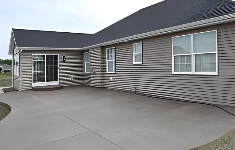 Backyard concrete patio poured along the back of a gray sided house, Brooksville, FL