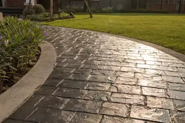 Curving dark stamped concrete walkway with a slate texture beside a lawn, Brooksville, FL